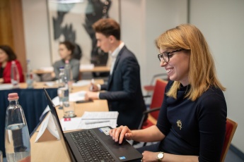 Foto eines Mädchens, das an einem Laptop bei einer Budapest-Konferenz arbeitet